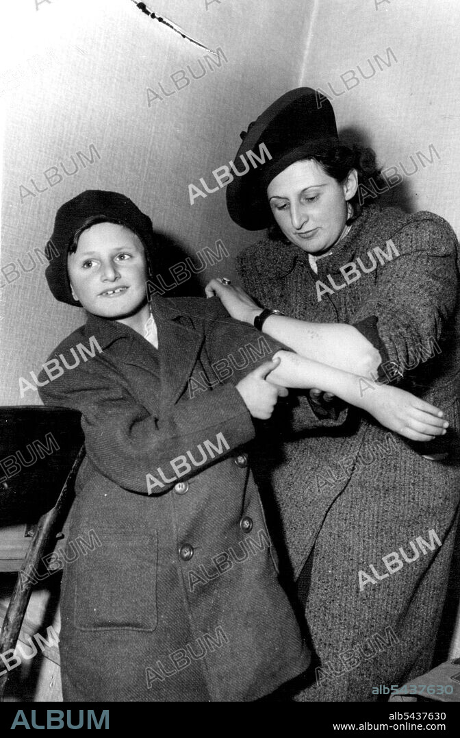 Mother And Son Reunited By Nazi Brands - They now Speak Different Languages -- Mrs. Ruth Friedhoff and her son, Peter Dattel, compare the identification numbers branded on their arms by the Nazis. The boy was traced by the number. Reunited by the identification numbers branded on their arms by the Nazis, a mother and child separated for years by suffering and now speaking different languages are together again in Berlin. They are Mrs. Ruth Friedhoff and nine-years-old Peter Dattel. Peter's fat.