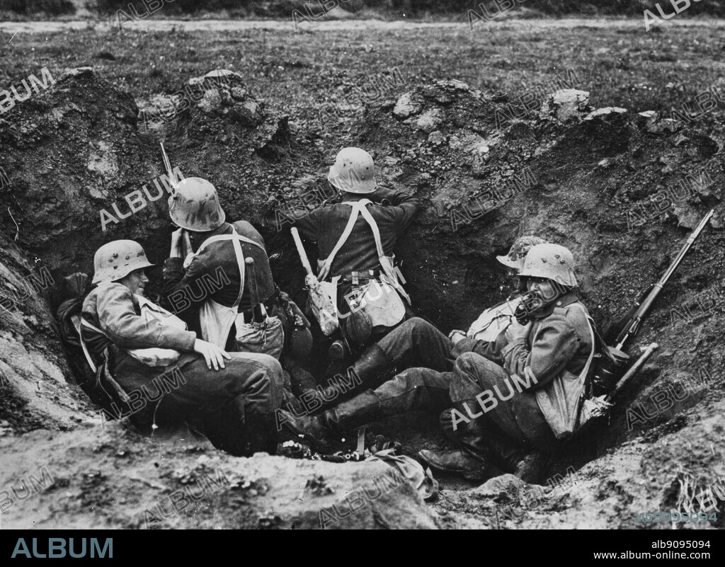 WW1: German soldiers at the Battle of Ypres. Manning a shell-hole; sentry and observer on duty with the other three resting.