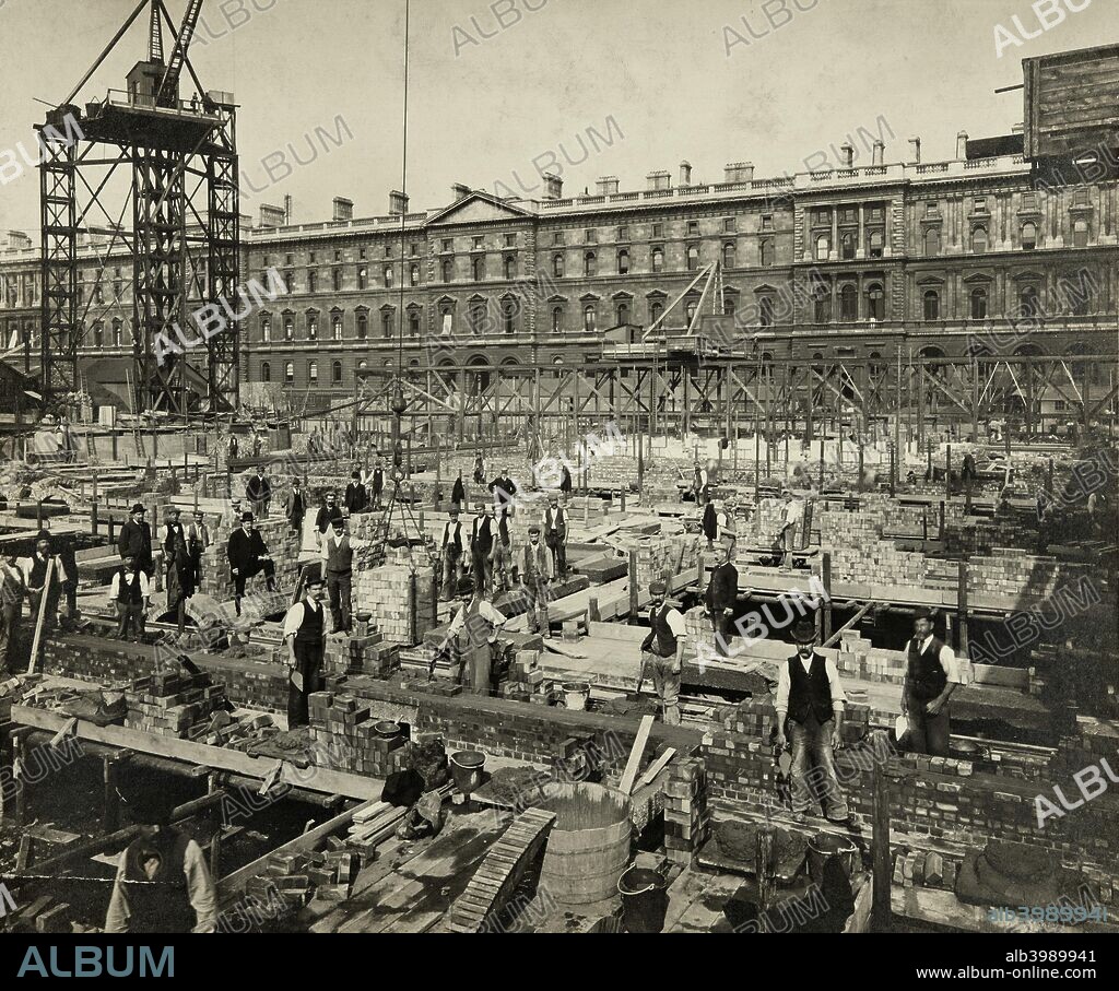 Construction of New Government Offices, Great George Street, Westminster, London, 1902. Work stops for a few moments during the building of New Government Offices, later HM Treasury. These buildings, designed by JM Brydon and Sir Henry Tanner of the Office of Works, were constructed in two phases, and were not completed until 1915. In the background is the previous generation of government offices by Sir George Gilbert Scott and Matthew Digby Wyatt built between 1861 and 1873. The architectural photography firm SB Bolas & Co took this photograph, and secured several other government contracts to record new buildings and temporary structures. Silver gelatin DOP print.