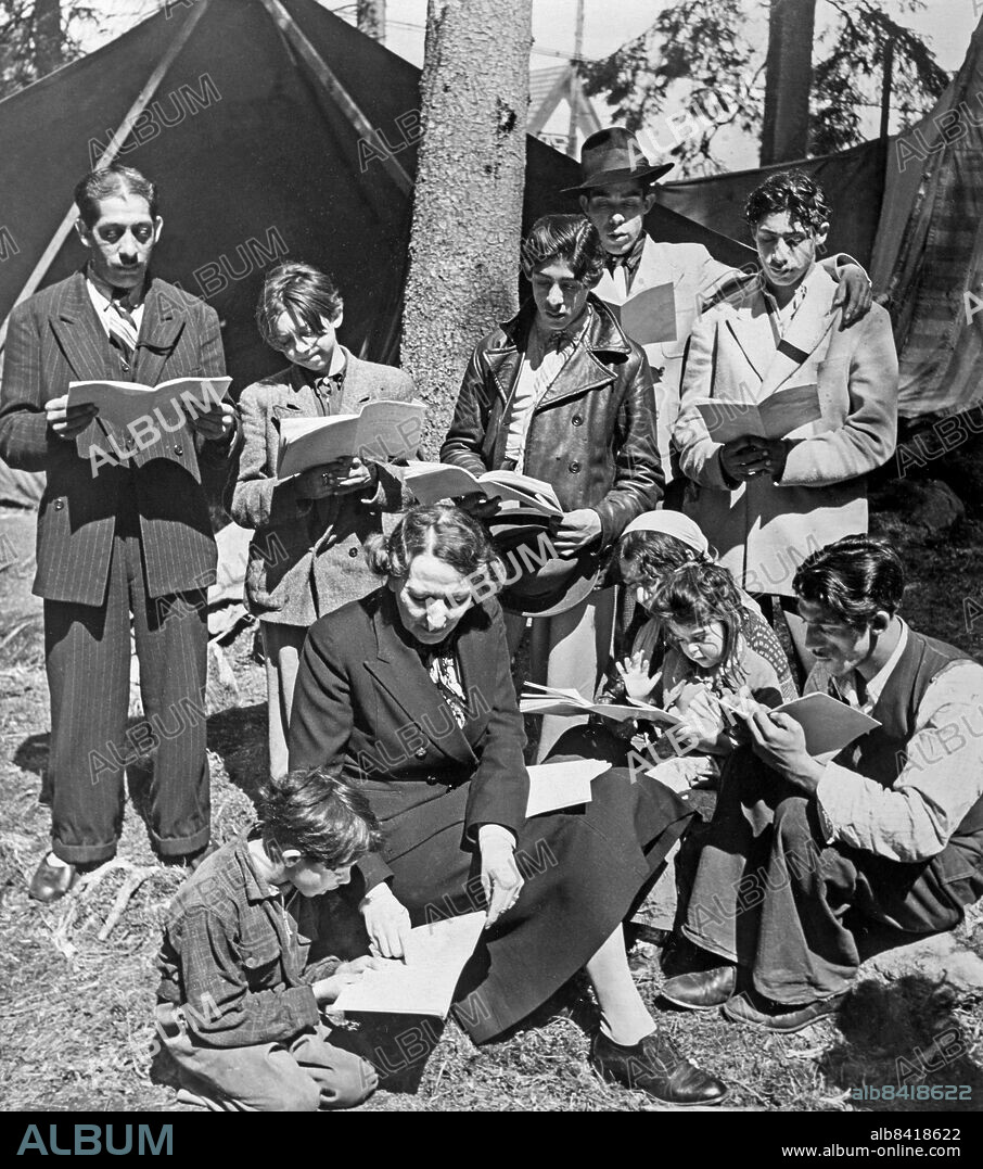 HINDÅS 1946-07-01. ORIGINALBILTEXT: . Sverige första ambulerande zigenarskola, med ett 15-tal elever, startade på söndagen i Hindås. Här har lärarinnan, fröken Sigrid Öhman, samlat zigenarfamiljen Josefsson omkring sig, och lektionen pågår, som syns, Foto: Pressens Bild / TT / kod 90.
