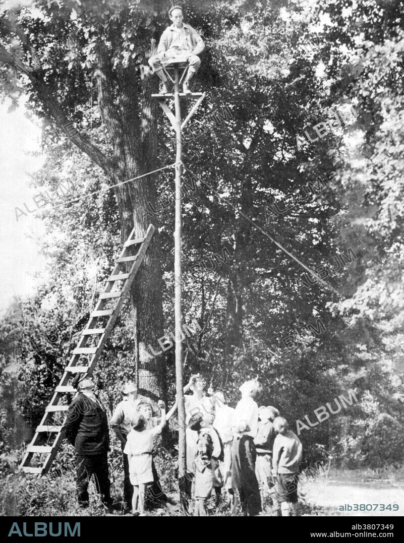 Unidentified flagpole sitter, 1920s. Flagpole sitting was a fad in 1920s. The fad was begun by stunt actor and former sailor Alvin "Shipwreck" Kelly, who sat on a flagpole, either on a dare by a friend or as a publicity stunt. Shipwreck's initial 1924 sit lasted 13 hours and 13 minutes. It soon became a fad with other contestants setting records of 12, 17 and 21 days. In 1929, Shipwreck decided to reclaim the title. He sat on a flagpole for 49 days in Atlantic City, New Jersey, setting a new record. The following year, 1930, his record was broken by Bill Penfield in Strawberry Point, Iowa who sat on a flagpole for 51 days and 20 hours, until a thunderstorm forced him down. Flagpole sitting in the 1920s was a major part of the decade. For the most part, pole sitting died out after 1929, with the onset of the Depression. Pole sitting is the practice of sitting on top of a pole (such as a flagpole) for extended lengths of time, generally used as a test of endurance. A small platform is typically placed at the top of the pole for the sitter.