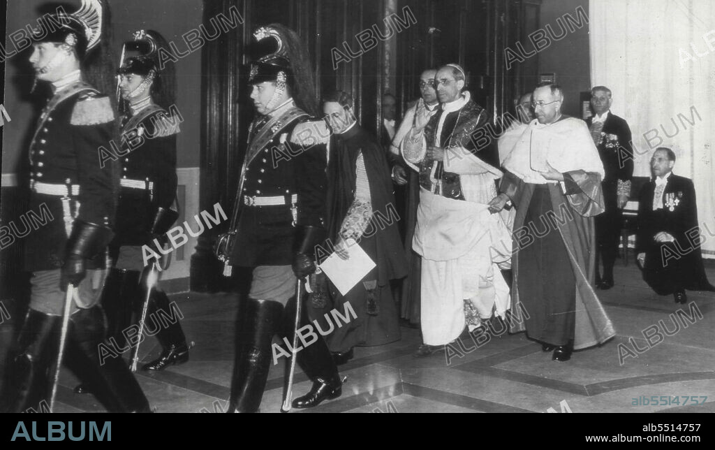 Pope Plus Proceeds To Secret Consistory -- Pope Pius XII Hall at the Vatican, Feb. 18, to attend Secret Consistory of the the college. Just behind the Guards is Msgr. Enrico Dante, carrying church. Walking with Pope Pius are Msgr. Frederico Callori Di are not identified. This photograph is by Frank Noel, cropped, of a radio, NY12 of Feb. 18. (Sixth from left), preceded by Noble Guards (left), goes to consistory Sacred College of Cardinals, during which 32 prelates were elevated to Pontiff's allocution declaring designation of new princes of the Vicale (left), attendant. And Msgr. Dieco Venini, attendant. Others Associated Photographer. February 21, 1946. (Photo by AP Wirephoto).