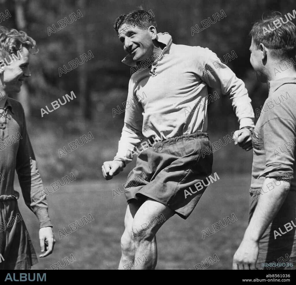GUSTAVSBERG STOCKHOLM 1958-05-31. Så här skall ni nicka grabbar, säger hoppande tränaren George Raynor inför beundrande Agne Simonsson (tv) och Sigge Parling.. Jumping coach George Raynor shows Agne Simonsson (left) and Sigge Parling how they should head the ball at a practice session during the World Cup in Football 1958.. George Raynor (1907-1985), English footballer and manager. He was the coach of Sweden's national football team during the 1940 - and 1950's. He led them to Olympic gold in 1948 and Olympic bronze 1952. In the World Cup, he managed to take Sweden to a bronze in 1950 and silver 1958.. Photo: Folke Hellberg / DN / SCANPIX / Kod: 23 *. ***OUT Svenska Dagbladet OUT**.