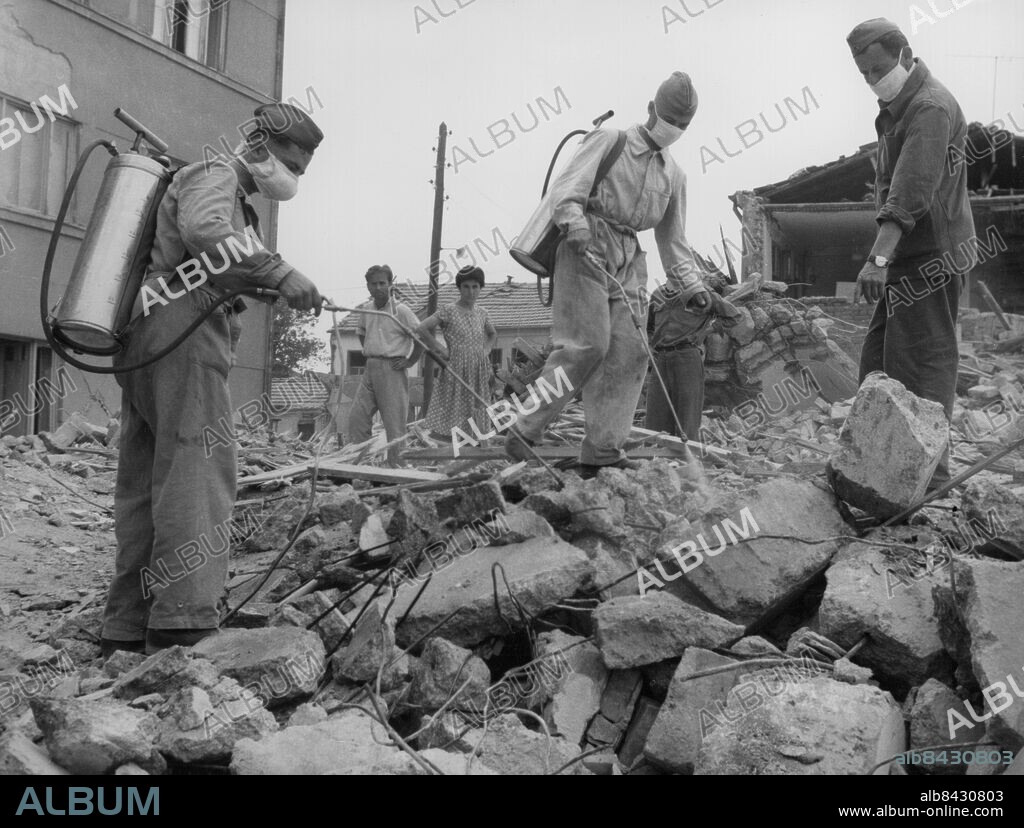 Orig. bildtext... EARTHQUAKE IN SKOPJE In the picture: All measures are undertaken to prevent the appearance of different deceases. Anm. Skopje blev 1945 huvudstad i den jugoslaviska delrepubliken Makedonien. En jordbävning ödelade 1963 ca 85 % av staden, som återuppbyggdes efter en internationell hjälpaktion. Se även XAD394, XAG279 och XAG303 Desinfektion Förebyggande Epidemier Desinficering Munskydd Sprutar Saneringsarbeten CD342 sites: JUGOSLAVIEN;MAKEDONIEN;SKOPJE.