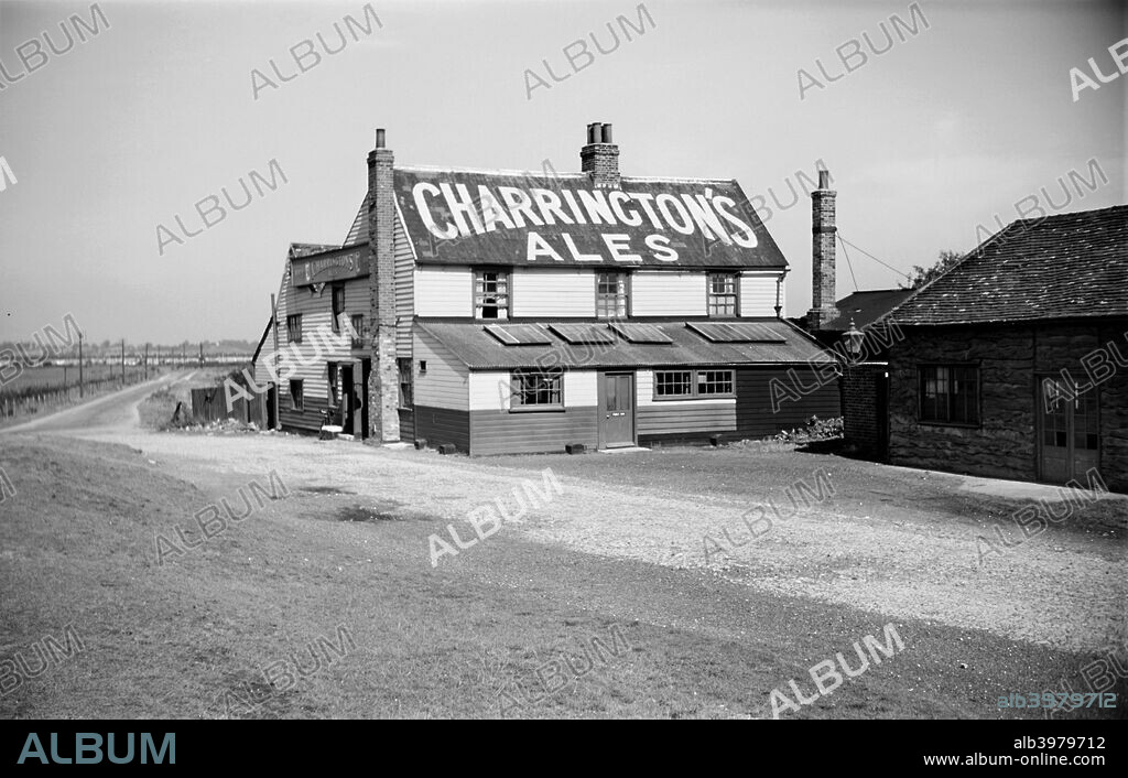 The World's End Inn, Fort Road, West Tilbury, Essex, c1945-c1965. The inn is an example of a typical Essex weatherboarded building. Charrington's Ales are advertised in huge letters on its roof.