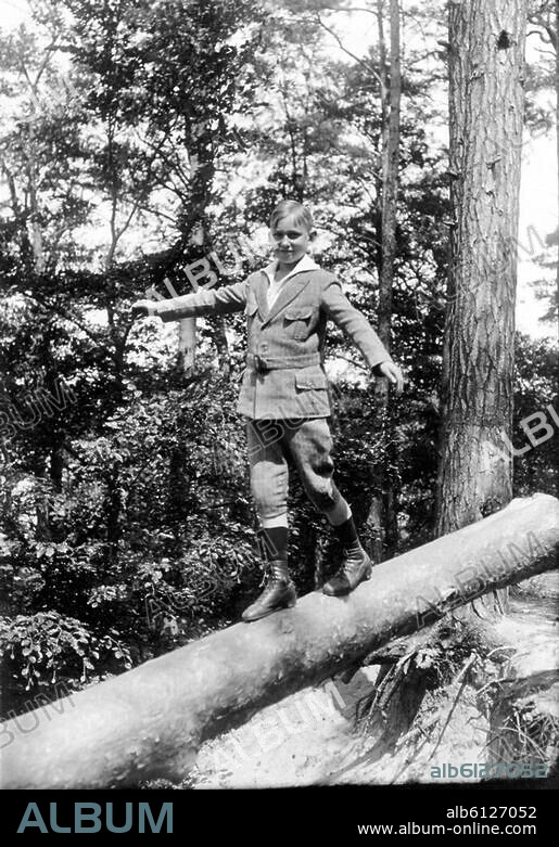 Kind / Kinderleben.-Ein Junge balanciert auf einem Baumstamm.-Foto.