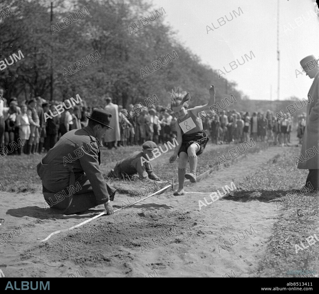 Göteborg - 1938-05-24 - Barn får pröva på friidrott - här en flicka som hoppar längdhopp medan vuxna mäter hoppet - *** Local Caption *** GT Låda 1938-maj-01. KAMERAREPORTAGE.