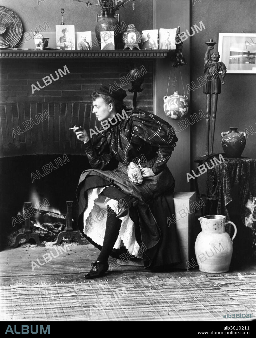 Johnston, seated in front of fireplace, facing left, holding cigarette in one hand and a beer stein in the other, in her Washington, D.C. studio, 1896. Frances "Fannie" Benjamin Johnston (January 15, 1864 - May 16, 1952) was one of the earliest American female photographers and photojournalists. She was given her first camera by George Eastman, a close friend of the family, and inventor of the Eastman Kodak cameras. She received training in photography and dark-room techniques from Thomas Smillie, director of photography at the Smithsonian. She took portraits of many famous contemporaries including Susan B. Anthony, Mark Twain and Booker T. Washington. Her most famous work is her self-portrait of the liberated "New Woman", petticoats showing and beer stein in hand. In the 1920s she became increasingly interested in photographing architecture, motivated by a desire to document buildings and gardens which were falling into disrepair or about to be redeveloped and lost. Her photographs remain an important resource for modern architects, historians and conservationists.was named an honorary member of the American Institute of Architects for her work in preserving old and endangered buildings. She died in 1952 at the age of 88.