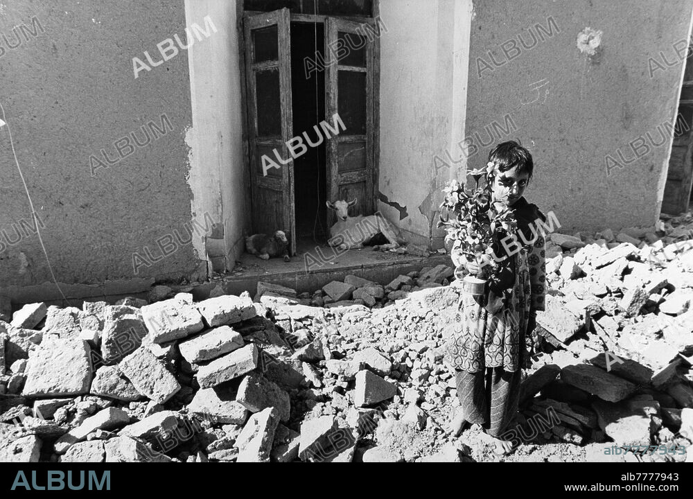 Iran / earthquake / Golbaft. A little girl holds a bouquet of artificial flowers after the earthquake that shook Golbaft in Kerman province, 1000 km southwest of Tehran, on June 11, 1981. In the small town with 5000 inhabitants, 80 to 90% of the houses were destroyed and more than a thousand people died. Photo, 17.06.1981.