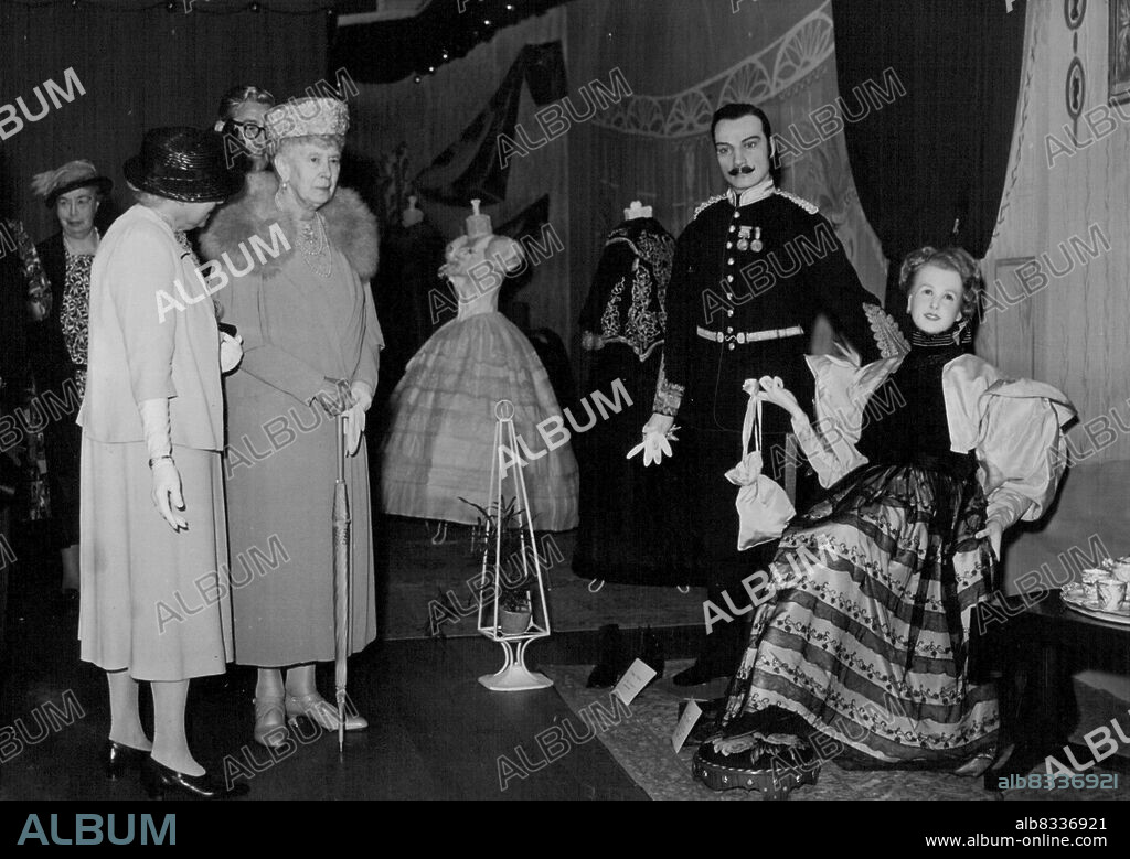 Queen Mary Visits Stoke To See Victorian Clothes Exhibition DG/FM/HA -- Queen Mary shows interest in a Crimea Soldier in Court Dress and a Tea Gown of 1882, during her visit. H.M. Queen Mary today visited a Kingston on Thames store (Bentalls) to see an exhibition of Victorian clothes. The exhibition is in aid of the Royal Cambridge Home for Soldiers Widows. June 04, 1951. (Photo by Fox Photos).