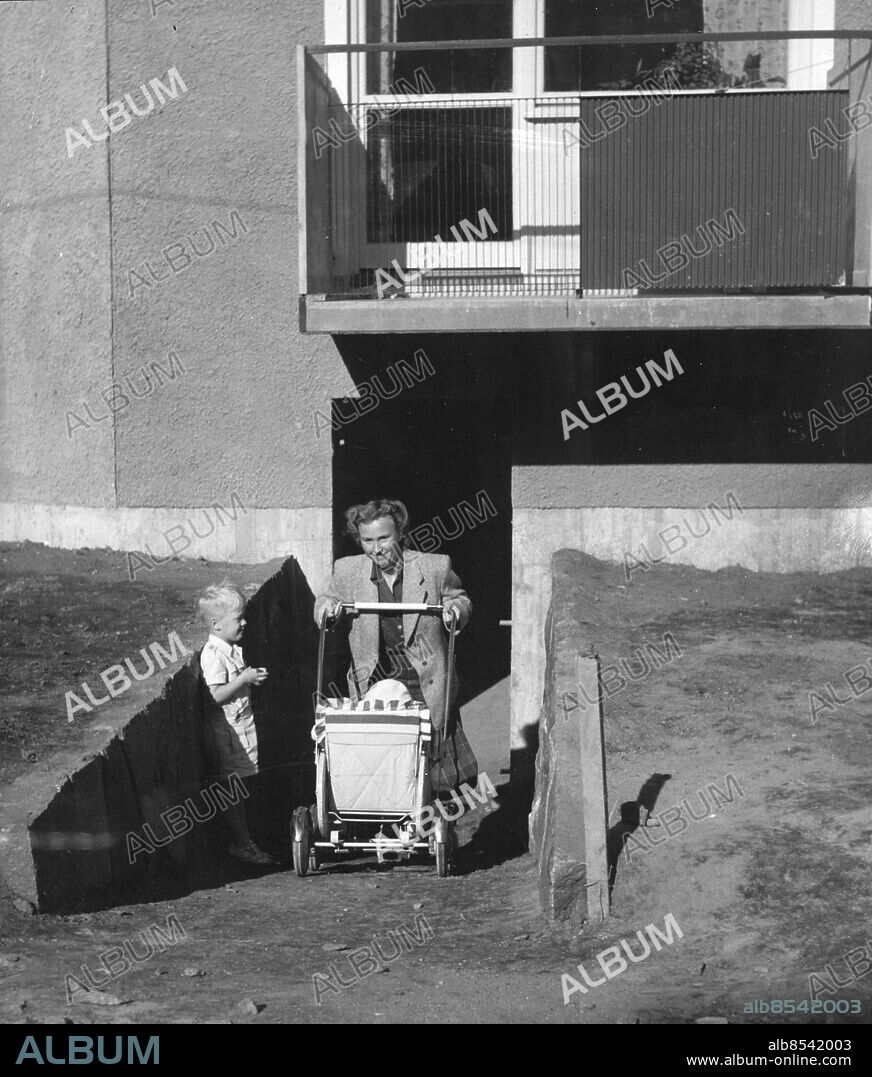 Stockholm 1949-09-14. Behändiga nedfarter för cyklar och barnvagnar har byggts i bostadshuset som kallas Långe Jan i Kärrtorp. Här fru Greta Billberg på väg ut med barnvagnen.. Foto: Expressen / TT / Kod: 192. ** AFTONBLADET OUT **.