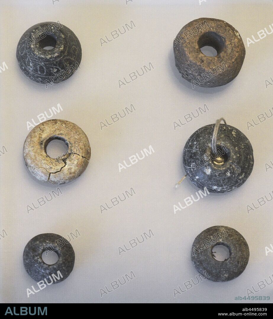 Industria textil. Edad Media. Fusayolas decoradas. Se colocaban en el huso como contrapeso. Torre de Hércules, La Coruña. Museo Arqueológico e Histórico (Castillo de San Antón). La Coruña. Galicia. España.