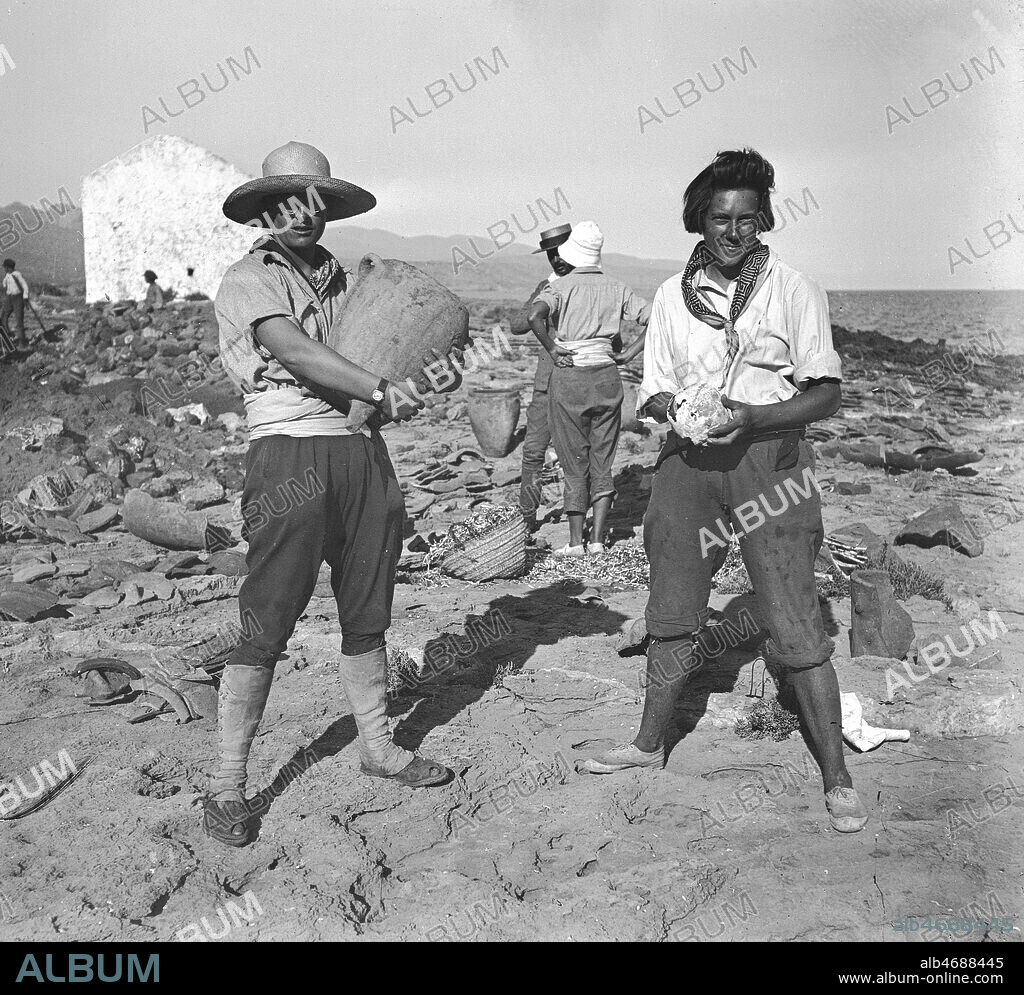 Hermine de SAUSSURE (1901-1984) portant une jarre antique et Ella MAILLART (1903-1997) tenant un crane decouverts sur le site archeologique de Mallia (de gauche a droite) lors du sejour en Crete des 5 jeunes filles (Ella Maillart dite Kini, Hermine de Saussure dite Miette, Yvonne de Saussure, Marthe Oulie dite Patchoum et Mariel Jean-Brunhes dite Riel) pour des fouilles archeologiques en 1925. Photo Mariel Jean-Brunhes (1905-2001). Credit: Brunhes-Delamarre/KHARBINE-TAPABOR.