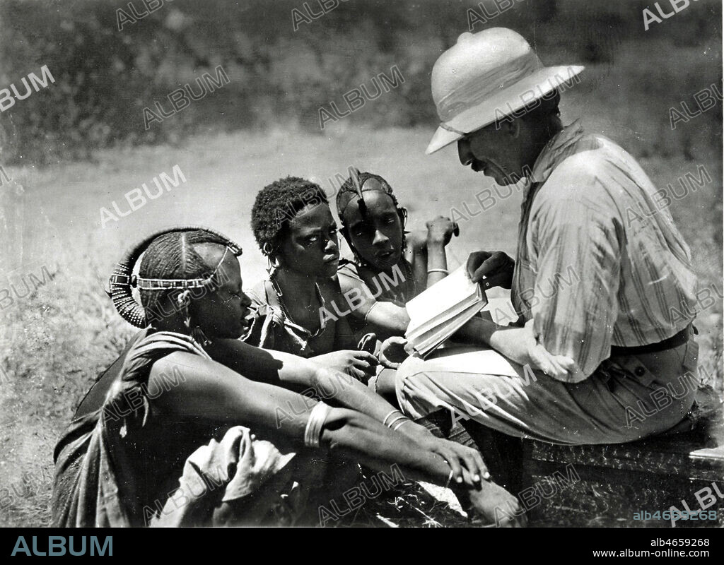 AFRIQUE Orientale, Colonie Allemande, Missionnaire allemand lisant l'ancien testament a des Massais . Photographie anonyme, annees 30. Collection privee. Credit Collection NB/KHARBINE TAPABOR.