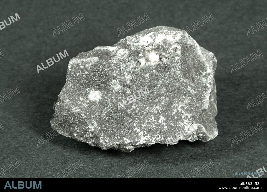 Hand sample of Basalt Porphyry, a dark-coloured intrusive igneous rock containing feldspar crystals in an aphanitic groundmass of plagioclase feldspar and hornblende.