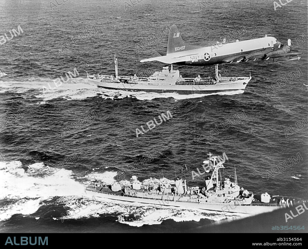Cuba:  1962 The Soviet freighter Anosov, rear, being escorted by a Navy plane and the destroyer USS Barry, while it leaves Cuba probably loaded with missiles under the canvas cover seen on deck.