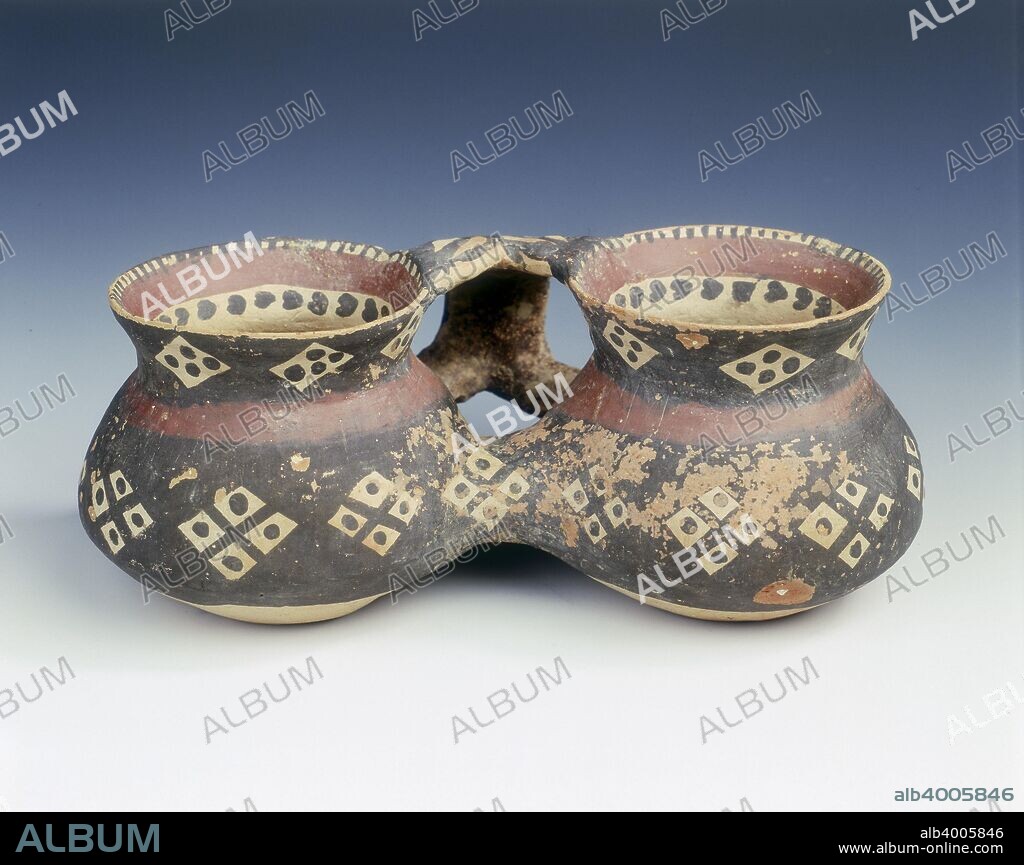 Painted pottery double cup, Yangshao culture, Machang type, China, c2500 BC. A double cup joined by a hollow tube at the base to allow liquid to pass from one cup to the other. A strap handle painted with black and red bands joins the lip and the lower body of both cups. The black band consists of quartered square windows in reserve with central dots. This pattern is repeated six times on the body and round the lip on each cup and once on each side of the connecting tube.