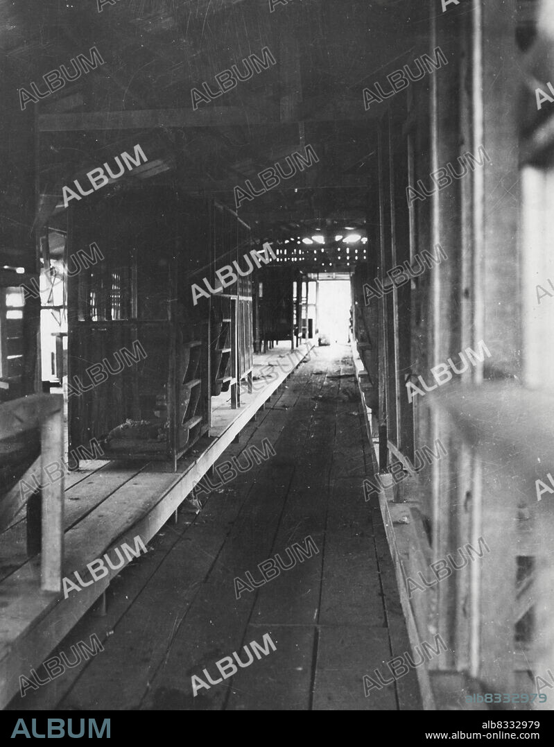 "Ghastly And Pitiful" Were Sights At The Davao Penal Colony --- Interior of the Prisoner of War barracks at the Davao Penal Colony reached through Jap lines in late May by men of the USAFFE Recovered Personnel Field Team and 130th Infantry guerrillas shows double tier bunking arrangement. Cribs are screened in with fine wire mesh. June 16, 1945.