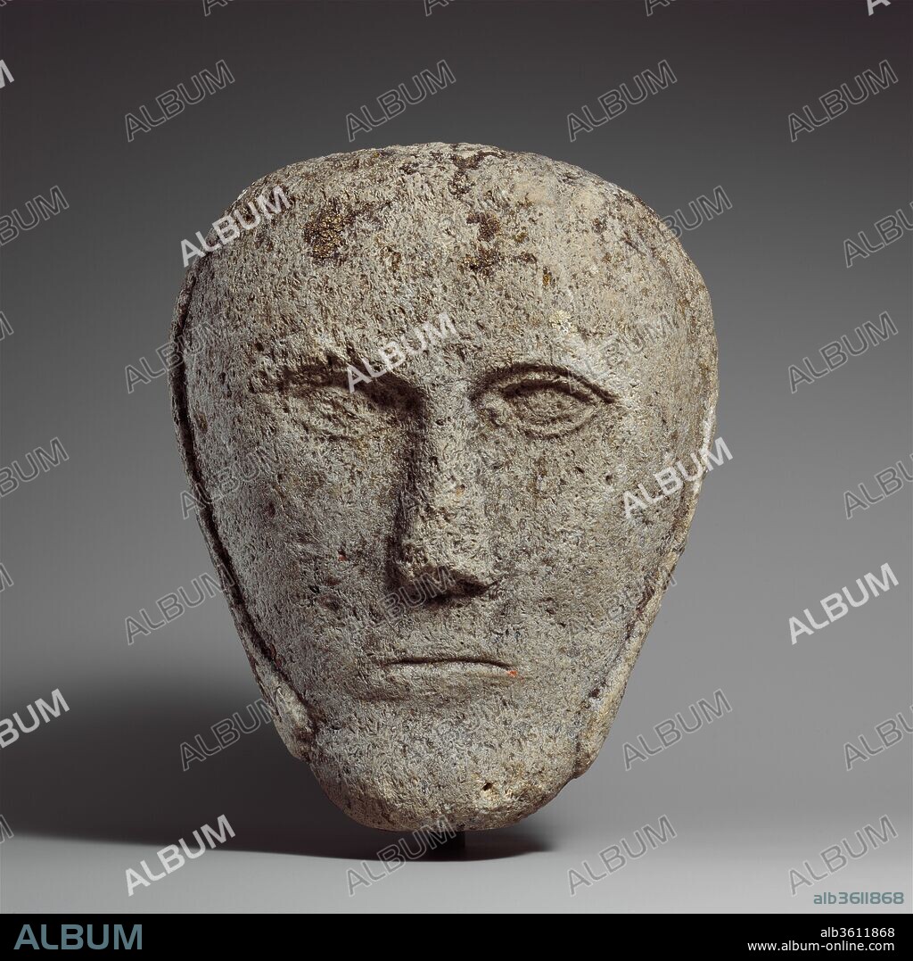 Head of a Man Wearing a Cap or Helmet. Culture: Celtic. Dimensions: H. 9 in. (24.1 cm). Date: possibly 2nd-3rd century.
The facial features are like those on numerous Celtic heads found in Yorkshire. Many, however, are actually products of later periods, continuing the simplicity of forms characteristic of Celtic sculpture. Stone heads like this one may have functioned as surrogates for actual human heads, thus retaining a certain aura of power. The military appearance of the headgear could indicate the man's status and significance.