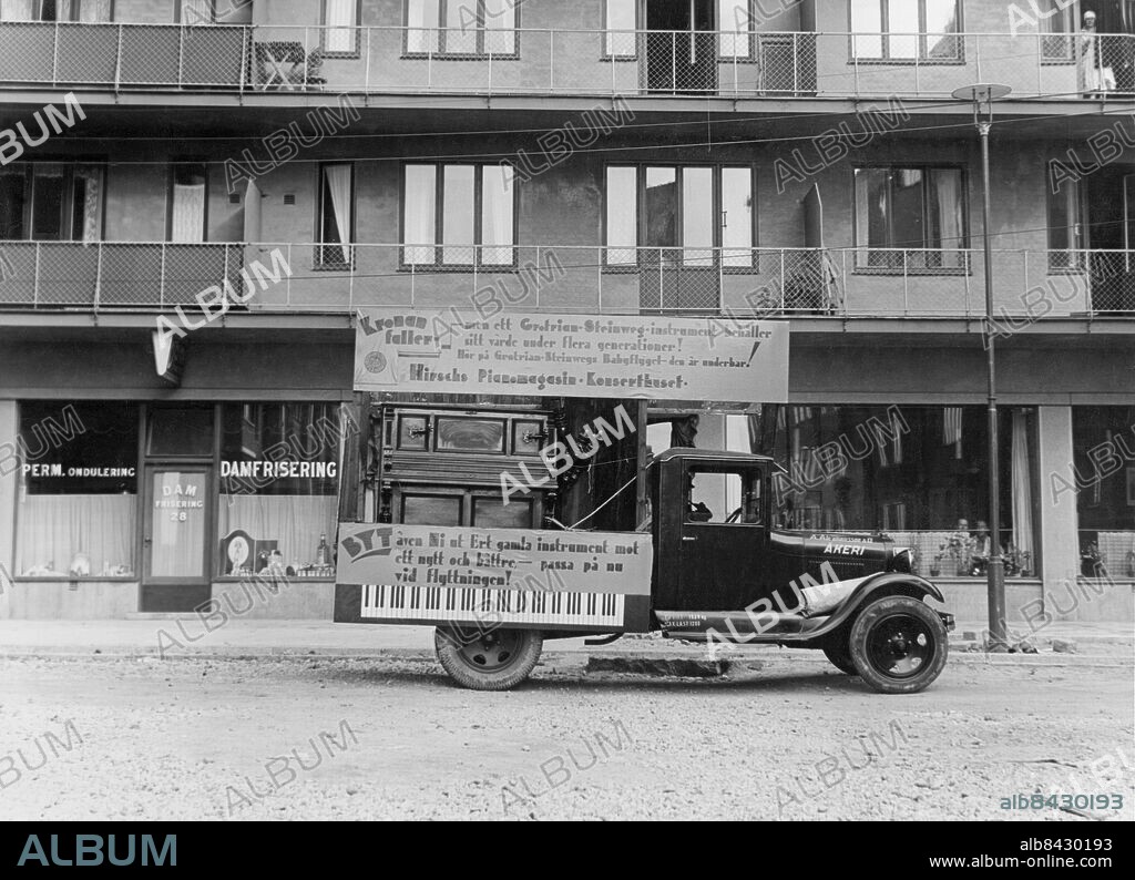STOCKHOLM 1930-tal.. Utan bildtext. Anm. Fasader Damfriseringar Lyktstolpar Balkongräcken På reklamskylten står: Kronan faller - men ett Grotrian-Steinweg-instrument behåller sitt värde under flera generationer! Hör på Grotrian-Steinwegs Babyflygel - den är underbar! Hirschs Pianomagasin Konserthuset BYT även Ni ut Ert gamla instrument mot ett nytt och bättre - passa på nu vid flyttningen! Lastbilens kylare är märkt A. Abrahamsson & Co ÅKERI CD320 sites: SVERIGE;STOCKHOLM.