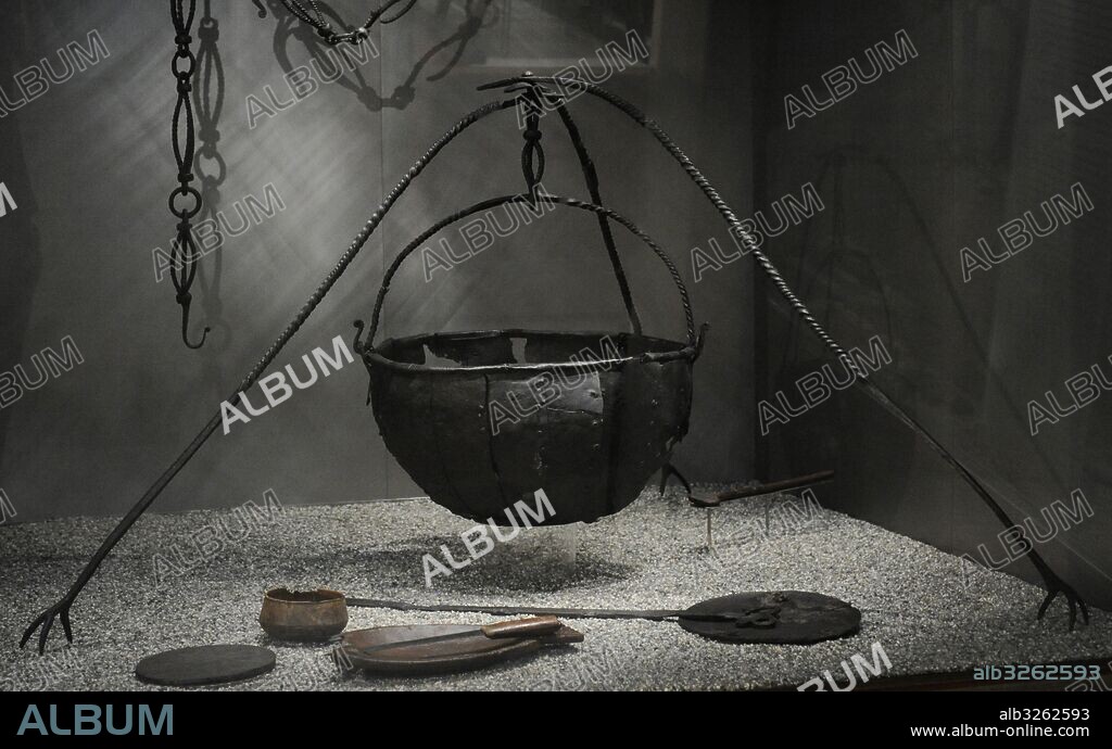Group of Viking utensils. Chain for cauldron and iron cauldron with tripod. In the bottom, wooden bowl, bowl and plate probably for fish, knife and frying pan. Found in the Tomb of the Oseberg Ship. 9th century. Viking Ship Museum. Oslo. Norway.