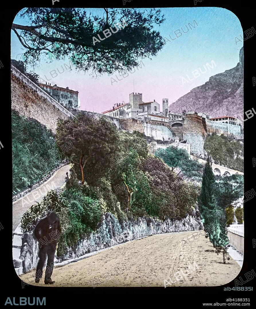 Magic Lantern slide circa 1900. Victorian or Edwardian era. The origional monchrome ( black and white ) photograph hand coloured.The photograph is the work of G.W. Wilson photographer and slide manufacturer 1823-1893.George Washington Wilson (7 February 1823 - 9 March 1893)  was a pioneering Scottish photographer. The French Riviera and Monte Carlo (lecture ) . Slide 44 The Princes Palace Monaco. The Prince's Palace of Monaco is the official residence of the Sovereign Prince of Monaco. Built in 1191 as a Genoese fortress, during its long and often dramatic history it has been bombarded and besieged by many foreign powers. Since the end of the 13th century, it has been the stronghold and home of the Grimaldi family who first captured it in 1297.
