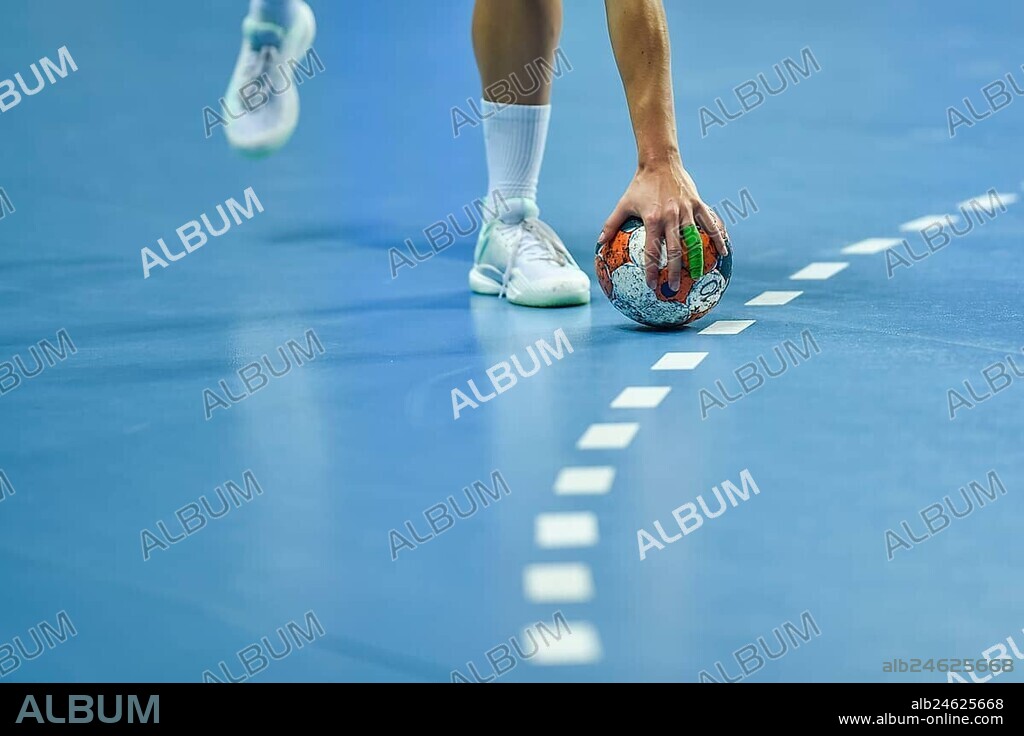 Handball - women's hand taking a ball laying on the 9 meters dotted line.