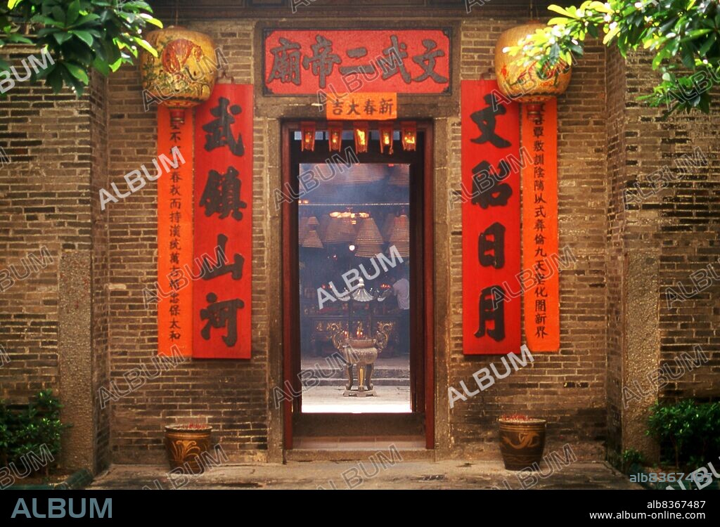 China: The entrance to the 19th century Man Mo Temple, Tai Po, New Territories, Hong Kong. The temple is dedicated to Man Cheong, the God of Literature, and Mo Tai, the god of Martial Arts.<br/><br/>. Originally a sparsely populated area of farming and fishing villages, Hong Kong has become one of the world's most significant financial centres and commercial ports. It is the world's tenth-largest exporter and ninth-largest importer.<br/><br/>. Hong Kong became a colony of the British Empire after the Qing Empire ceded Hong Kong Island at the end of the First Opium War in 1842.
