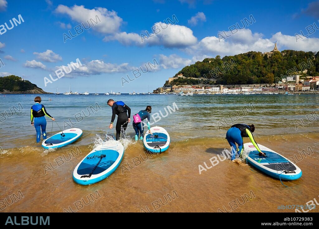 Grupo de turistas practicando paddle surf en la Bahia de La Concha, SUP, Stand Up Paddle, Donostia, San Sebastian, Pais Vasco, España.