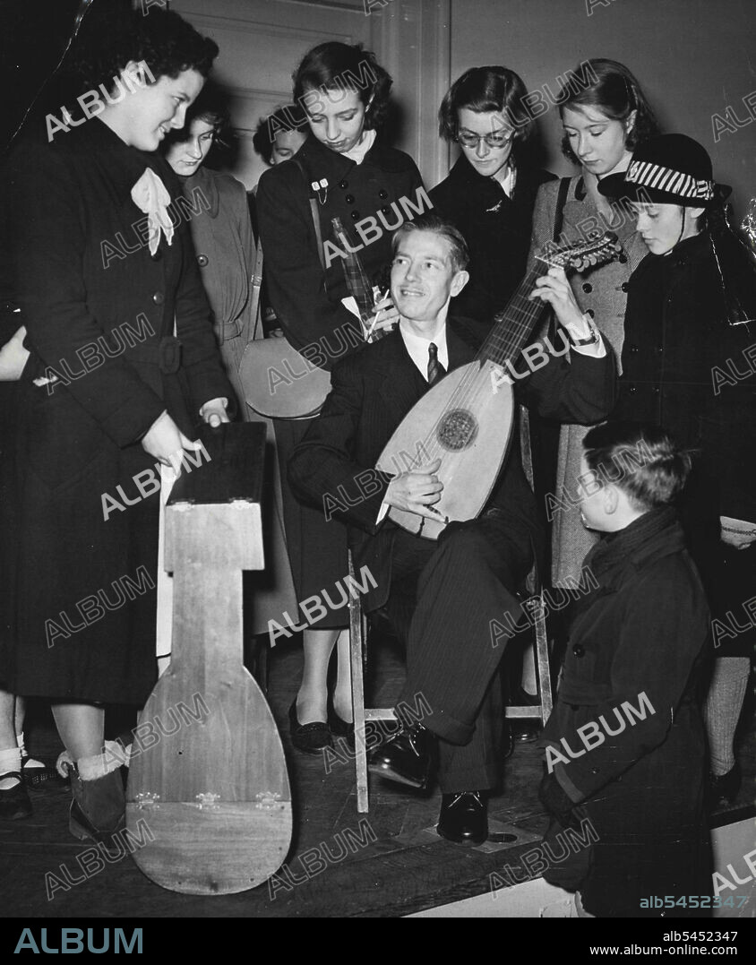 Early Musical Instruments -- Mr. Carol Dolmetsch plays the Lute for his interested young listeners during his demonstration and commentary on early musical instruments, at the Horniman Museum, Forest Hill, London. The lute he is seen playing is an early German type of about 1700.A number of schoolchildren with an interest in music and musical instruments, attended a demonstration and descriptive commentary given by Mr. Carol Doolmetsch F. T. C. I. on " Early Musical Instruments and their Music" at the Horniman Museum, Forest Hill, London, during their Arms holidays. Mr. Dolmetsch, is a member of the famous early musical instruments, plays all the instrument that he demonstrates. January 05, 1953. (Photo by Fox Photos).