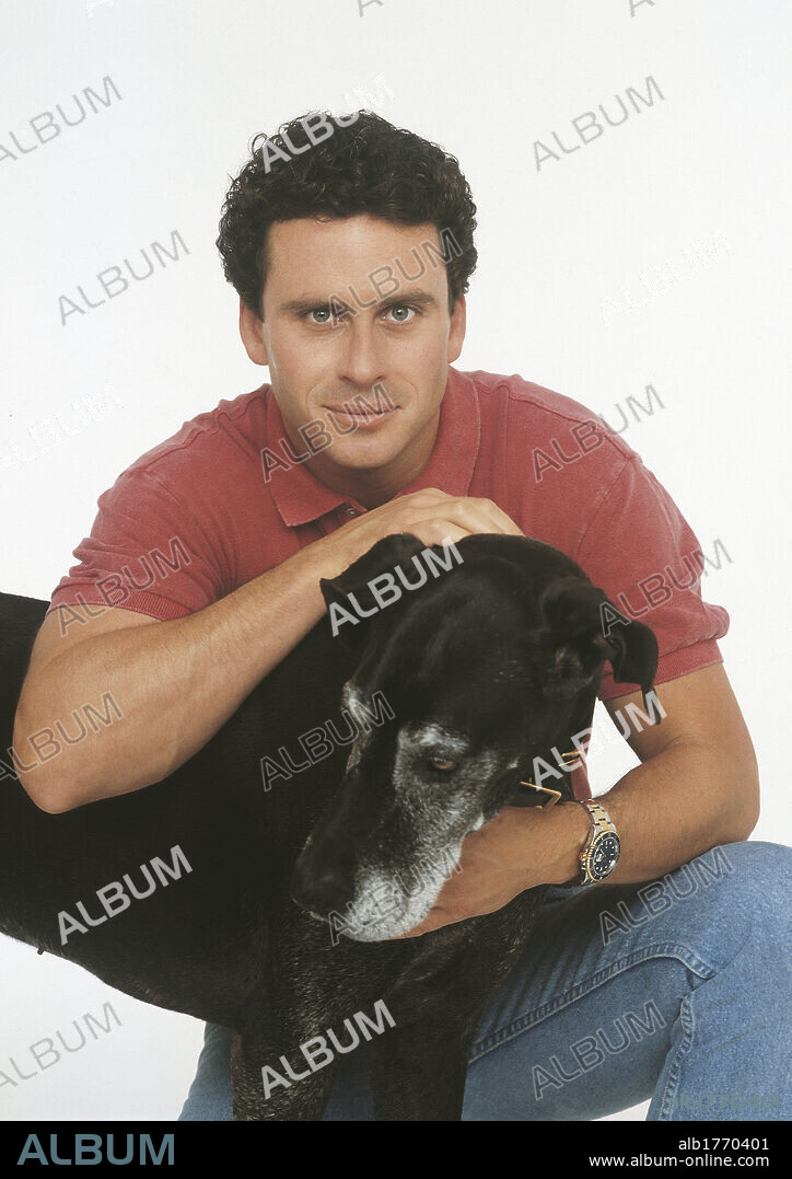 Ethan Wayne with a dog. The U.S. actor Ethan Wayne hugging and curling a big dog. 1991.