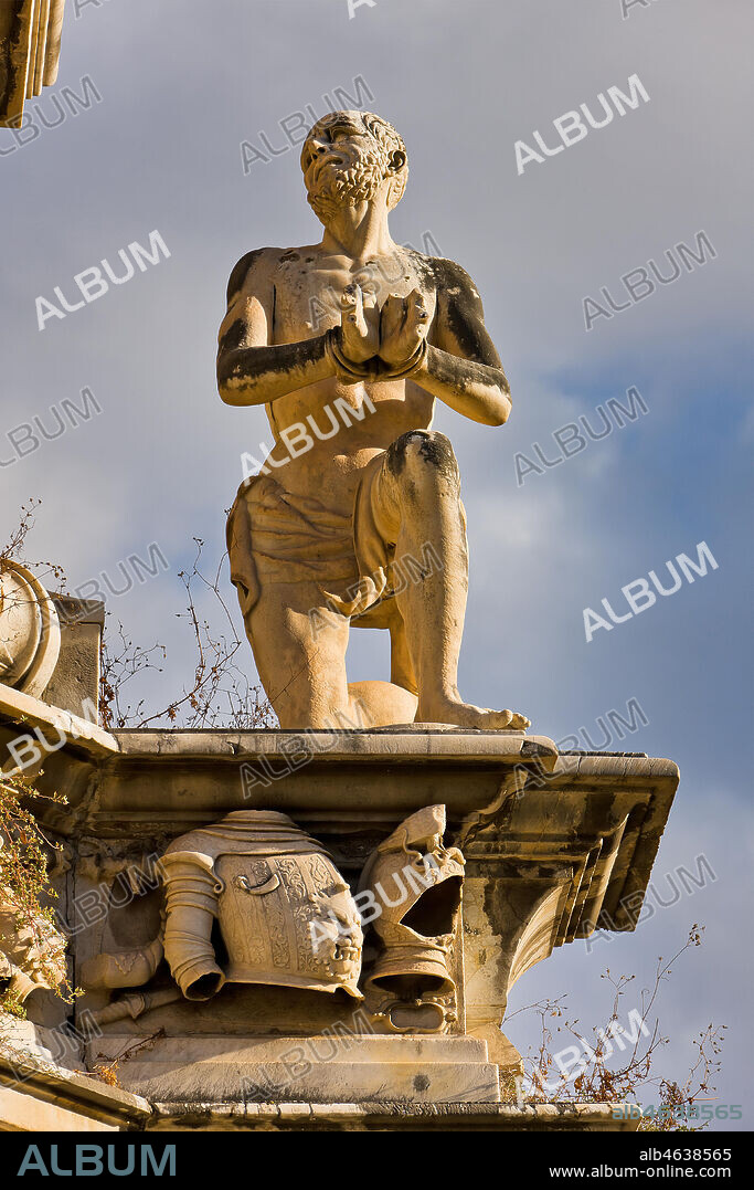 Palermo, the Parliament Square: The Marble Theatre, monument to Philip V, facing The royal Palace or Palace of the Normans. It was realised by Gaspare Guercio, Carlo D'Aprile and Gaspare Serpotta to celebrate the glory of Philip IV of Habsburg, king of Spain and Sicily, called Philip the Great.. Around the pedestal the four parts of the Earth known at that time (Europe, Asia, Africa and America), on which the king of Spain ruled, are depicted. On the first level there are the statues of the four Moors, or the previous kings of the countries that went under his domination. The work is adorned with plaques and coats of arms of the most important families in Sicily. The original statue of Philip IV was destroyed during the Sicilian revolution in 1848 and was replaced in 1856 by the current marble statue representing King Philip V of Spain and was realised by Nunzio Morello.. Detail representing a captured Moor.