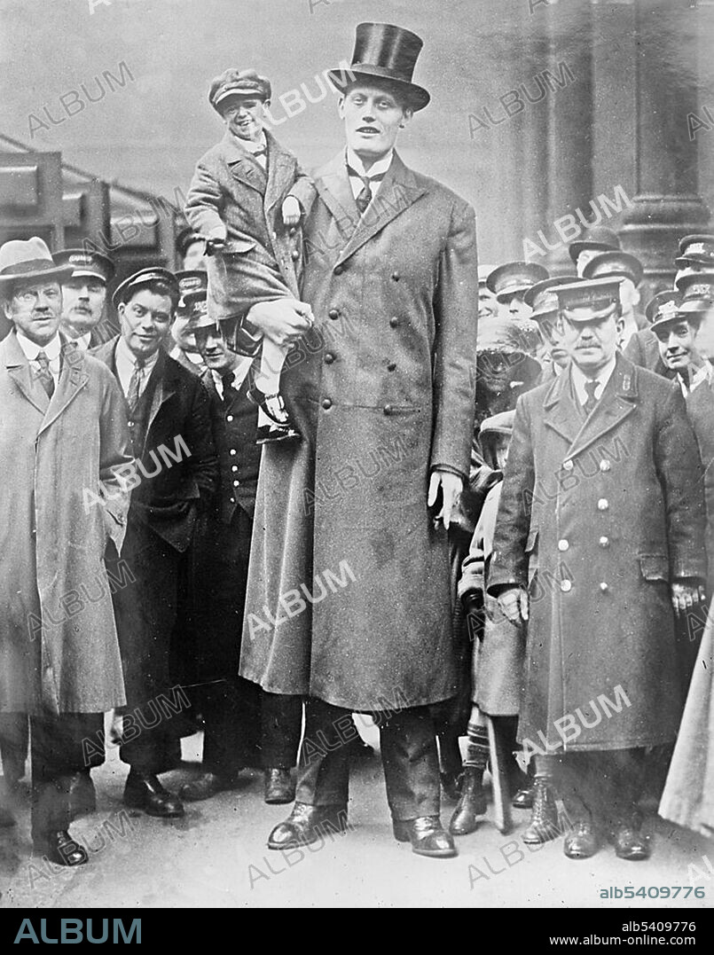 A photograph of Albert Johan Kramer, a giant, holding Fred Aslett, a dwarf. Kramer is 8 ft 9 3/4 inches; Aslett is 2ft 4 inches. The rest of the people are of normal height. Gigantism is a rare disorder resulting from increased levels of growth hormone before the fusion of the growth plate, which usually occurs at some point soon after puberty. This increase is most often due to abnormal tumor growths on the pituitary gland. Dwarfism can result from many medical conditions, each with its own separate symptoms and causes. Extreme shortness in humans with proportional body parts usually has a hormonal cause, such as growth-hormone deficiency, once called pituitary dwarfism. Two disorders, achondroplasia and growth hormone deficiency, are responsible for the majority of human dwarfism cases.