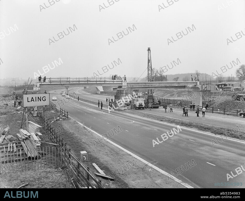 JOHN LAING PLC. A  view of a footbridge under construction at the Newport Pagnell Service Area on the M1, the London to Yorkshire Motorway, showing traffic on the northbound carriageway. This image was catalogued as part of the Breaking New Ground Project in partnership with the John Laing Charitable Trust in 2019-20.