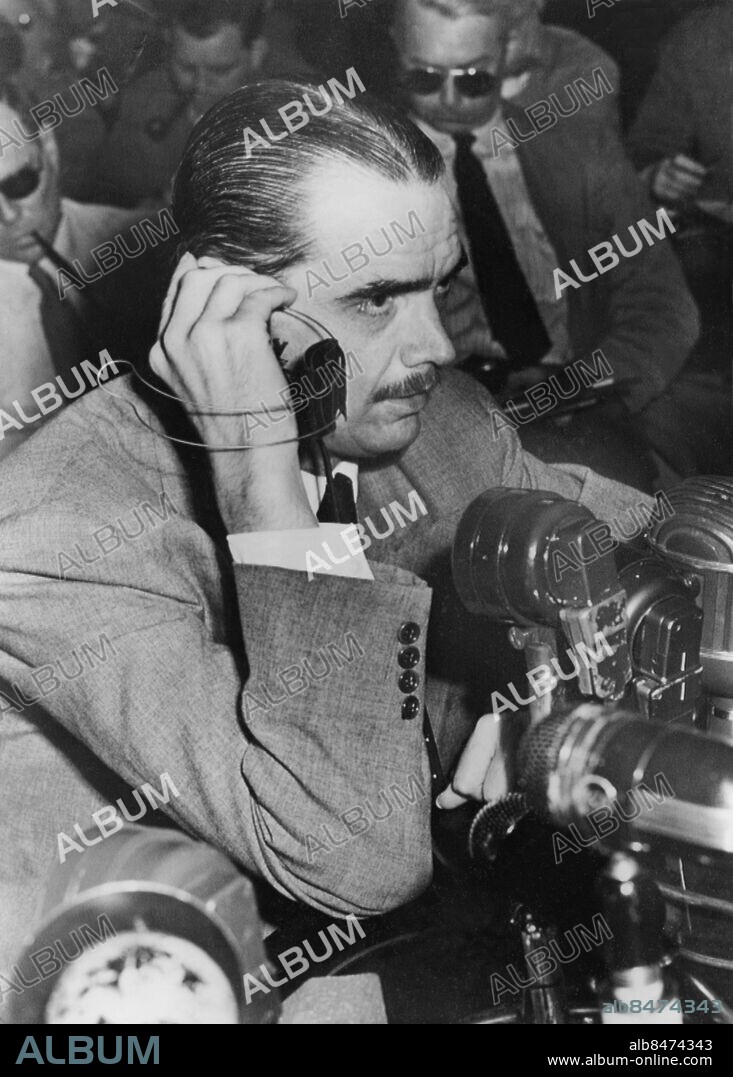 Orig. bildtext... AS HUGHES RENEWED BREWSTER CHARGES Washington, D.C. Howard Hughes, partially deaf multimillionaire airplane builder, is shown using a special hearing aid provided by the senate war investigators probing his wartime aircraft contracts, as he testified at today's session of the investigation. Hughes fired a new volley of accusations at chairman Owen Brewster, (r) of Maine., one of the probers, calling Brewster the greatest trick shot artist in Washington. The fire was directed at Brewster's blanket denial that he offered to quash investigation of Hughes' war plane contracts if Hughes would merge his Trans-World Airline with Pan American Airways. Anm. Senatförhör angående affärer under kriget H Hughes, 1905-1976, amerikansk industriman, flygare och filmproducent Hörlurar CD358 persons: HOWARD HUGHES sites: WASHINGTON DC;USA.