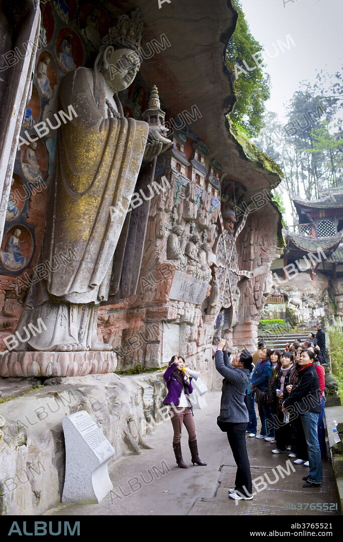 Tourists at Dazu rock carvings of Buddha of Mercy at Mount Baoding, Chongqing, China.