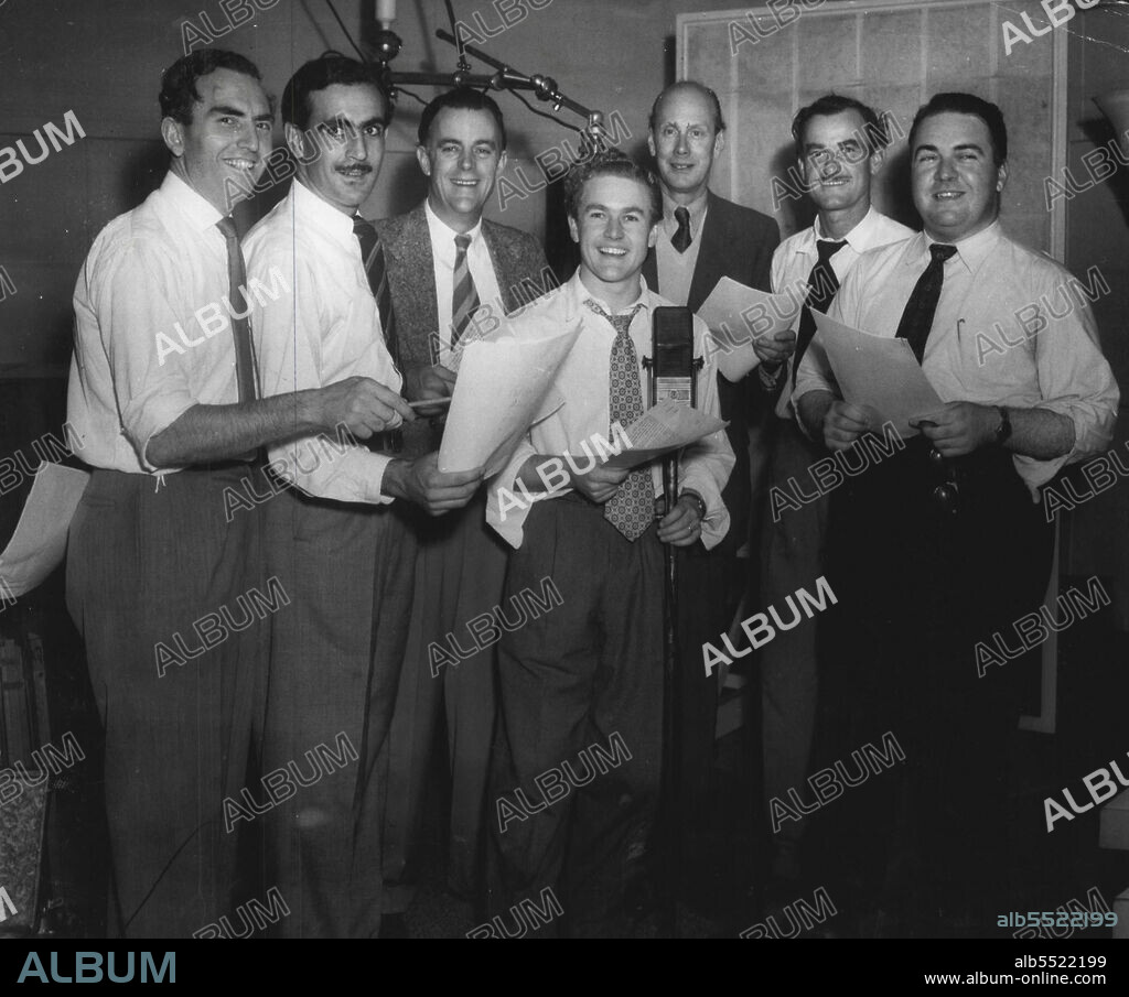Cast of Biggles at the recording of the 1000th episode of the popular serial. From left: Frank Waters, Walter Sullivan (Bertie), Leonard Bullen, John Ewart, James Mills (Biggles), Max Osbiston and Kevin Brennan. Serial produced the AWA Studios by J. Colin Craigen is heard nightly on 2CH at 6.0. May 01, 1953. (Photo by Gervaise Purcell ).