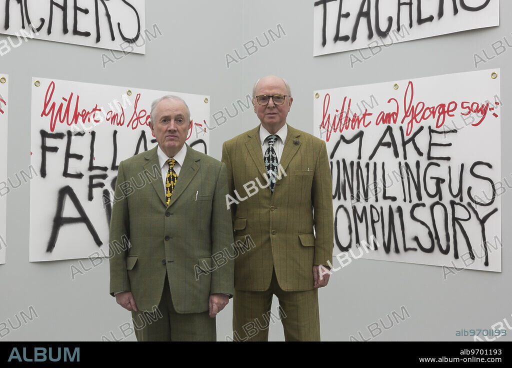 London, UK. 8 December 2015. Pictured: L-R: Gilbert & George in front of their artworks The Banners. Artists Gilbert & George launch their latest publication The Banners, as well as 10 poster designs, made to coincide with their exhibition at White Cube Bermondsey. The exhibition The Banners runs from 25 November 2015 to 24 January 2016. Photo: Bettina Strenske,Image: 527652224, License: Rights-managed, Restrictions: WORLD RIGHTS - Fee Payable Upon Reproduction - For queries contact Photoshot - sales@photoshot.com London: +44 (0) 20 7421 6000 Florida: +1 239 689 1883 Berlin: +49 (0) 30 76 212 251, Model Release: no, Credit line: Bettina Strenske / Avalon.