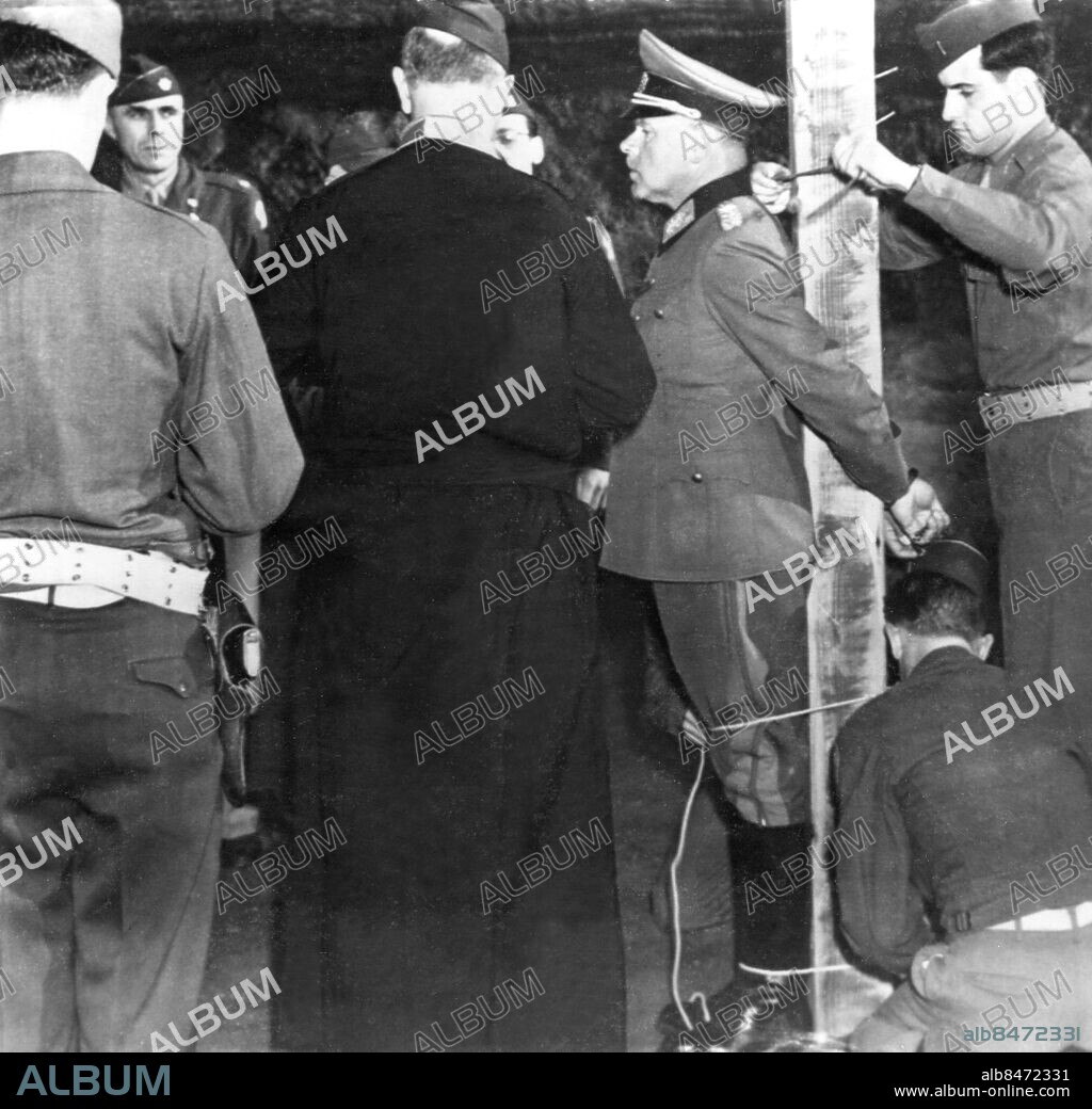 Orig. bildtext... A NAZI GENERAL PREPARES TO MEET HIS DOOM. Aversa, Italy. General Anton Dostler, first german high commander to be tried by U.S. court martial and condemned to death, is shown being tied to the execution stake here last week. The american chaplain standing with back to camera prayed to Dostler just before the execution by firing squad. Anm. A Dostler, 1891-1945, tysk general. Dömdes till döden 1 december 1945. Efterkrigstiden Avrättningar Fastbunden Binda fast Profiler CD449 persons: ANTON DOSTLER sites: USA*;ITALIEN;TYSKLAND*.