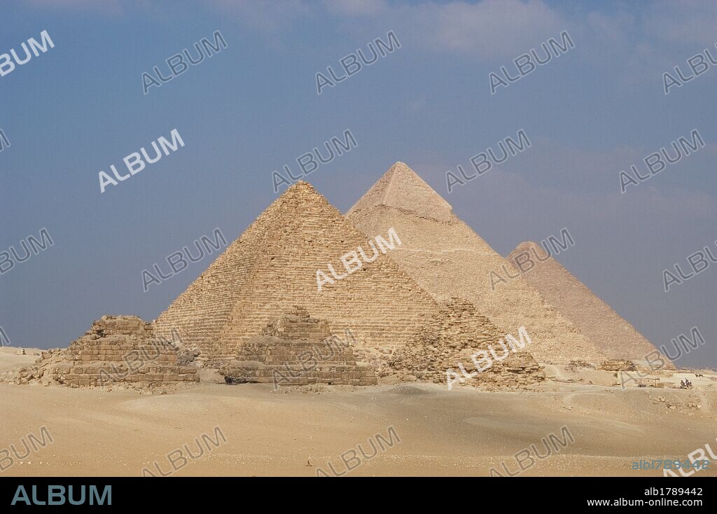 ARTE EGIPCIO. Vista desde el mirador de las tres pirámides. De izquierda a derecha: PIRAMIDE DE MENKAURA (MICERINOS), con sus tres pequeñas pirámides satélites. La PIRAMIDE DE JAFRA (KEFREN), que conserva intacta la capa de piedra caliza que recubre la cúspide. La Gran PIRAMIDE DE JAFU (KEOPS). IMPERIO ANTIGUO. IV DINASTIA. Siglo XXVI a. C. Meseta de EL GIZA. Egipto.