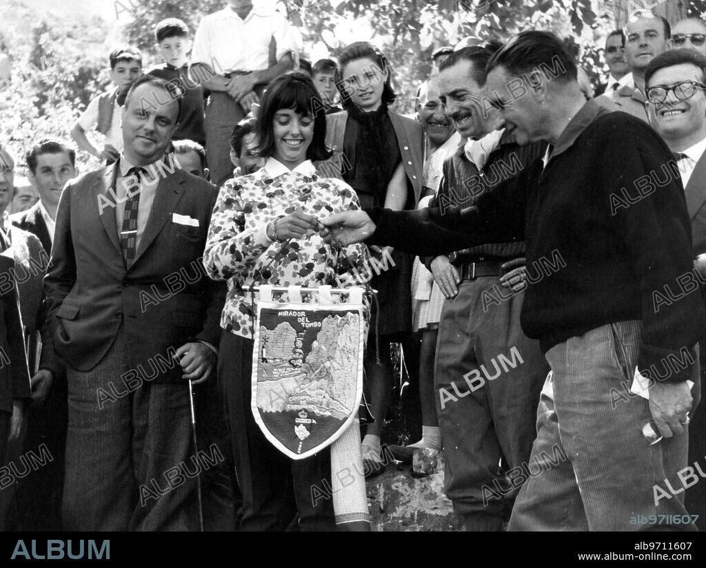 1964. La Señorita María del Carmen Fraga, Hija del ministro de información y turismo en el momento emocionante de recibir el banderín conmemorativo de Manos del señor presidente de Montañeros de Peñalba de León, Sr. Diego Mello.