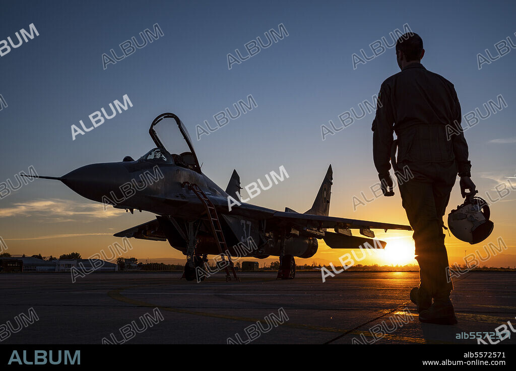 Pilot walking to a Bulgarian Air Force MiG-29 aicraft during sunset at Graf Ignatievo Air Base, Bulgaria, for a night mission sortie.