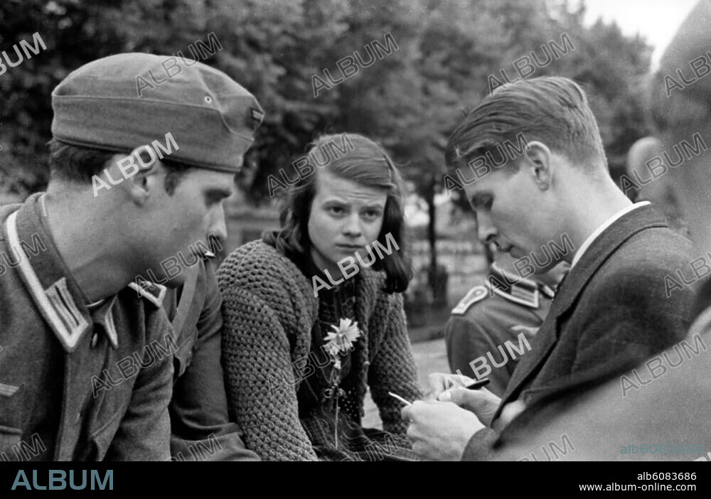 Scholl, Sophie; Widerstandskämpferin, Mitglied der Widerstandsgruppe "Weiße Rose"; Forchtenberg (Hohenlohekreis) 9.5.1921 - (hingerichtet) München 22.2.1943. Mitglieder der "Weißen Rose" von links Hans Scholl (1918-1943), Sophie Scholl u. Christoph Probst (1919-1943). Aufnahme Wittensteins bei der Militärsammelstelle ihrer Münchner Studentenkompanie am Ostbahnhof München zur Abkommandierung an die Ostfront. "Christl trägt Zivil: er war nicht in unserer Heeresabteilung Artillerie, sondern bei der Luftwaffe und in Innsbruck stationiert, wo er Medizin studierte, wie wir in München. Er reiste - vermutlich illegal - an, um uns zu verabschieden. Sonst hätte er seine Luftwaffenuniform getragen" (rechts im Bild, angeschnitten: Willi Graf).