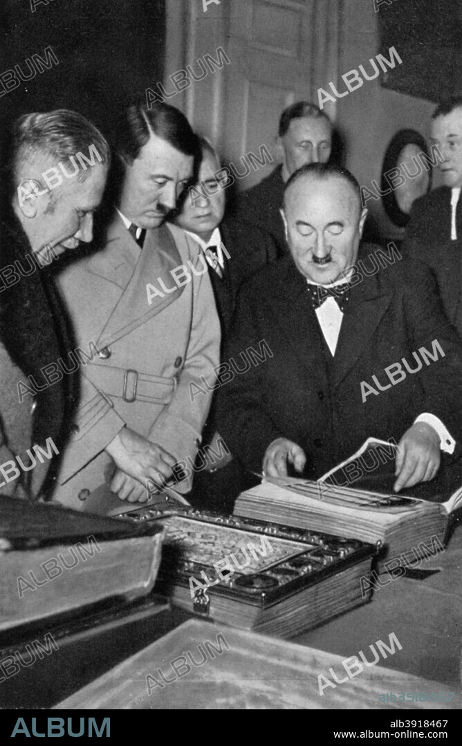 Adolf Hitler being shown the treasures of the Bavarian State Library, Germany, 1936. A print from Adolf Hitler. Bilder aus dem Leben des Führers, Hamburg: Cigaretten/Bilderdienst Hamburg/Bahrenfeld, 1936.