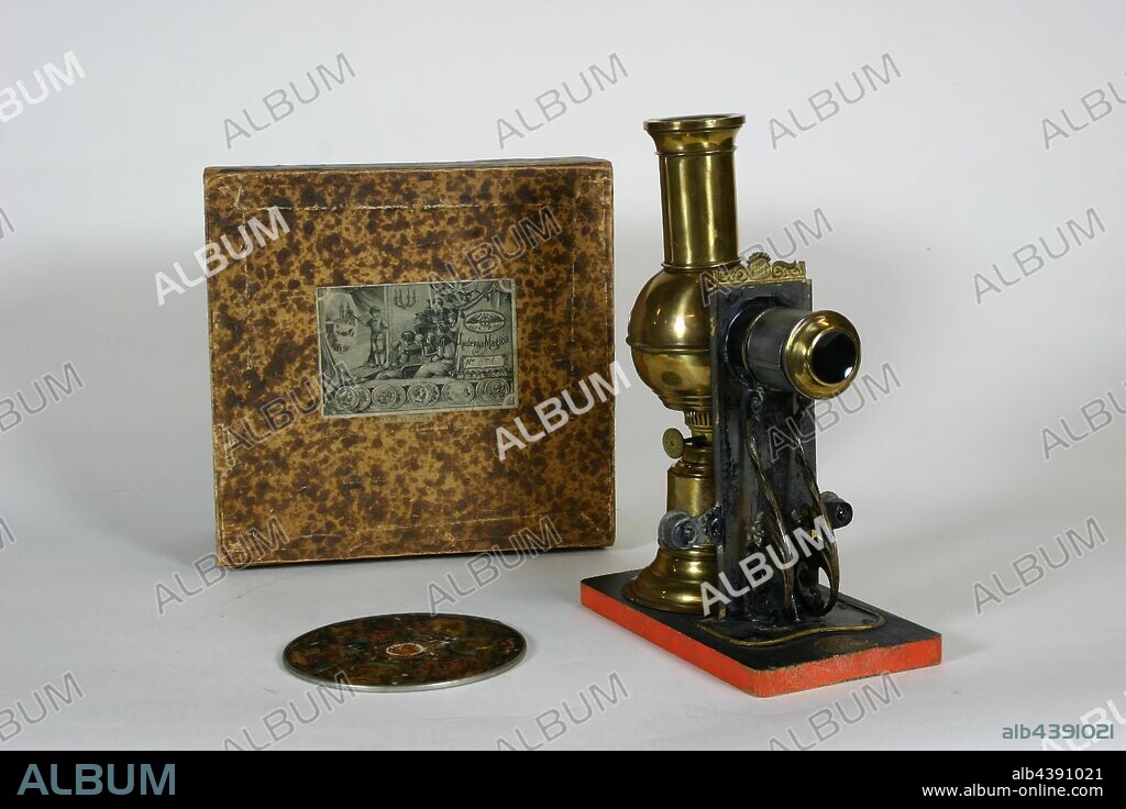 Projector Set - Ernst Plank, Magic Lantern, Toy, Brass Climax, Germany, 1890s, Children's toy magic lantern projector, designed for domestic use with circular glass slides. Includes box and two circular slides. The 'Brass Climax' was a special variant of the 'Climax' model and was produced specifically for the British and United States markets. The body is of polished brass and uses a single wick kerosene burner as an illuminant. The ornate slide holder is of die pressed.