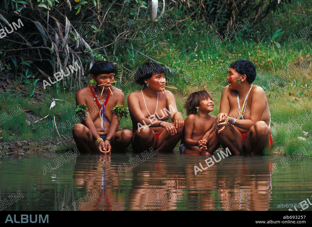 Nov 27, 2003; Boa Vista, Amazonas, BRAZIL; Three Yanomami women with facial piercings and decorative band jewlery sit on ther ankles at the waters edge with a Yanomami child. The Yanomami Indians are one of the last Stone Age tribes in the world. Their habitat lies on the border between Brazil and Venezuela where close by a giant gas and oil company, Petrobas, has built a refining and transport plant to harvest the land which is rich in resources. Mandatory Credit: Photo by Antonio Mari/ZUMA Press. (©) Co. 27/11/2003