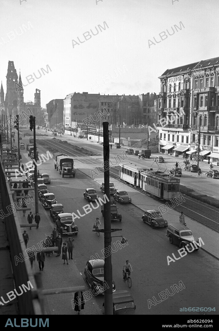 View on Tauentzienstraße, a street in West Berlin, with the tram on the median strip and Kaiser-Wilhelm-Gedächtniskirche (a church), which was seriously damaged during the Second World War, pictured in 1950. 1950
