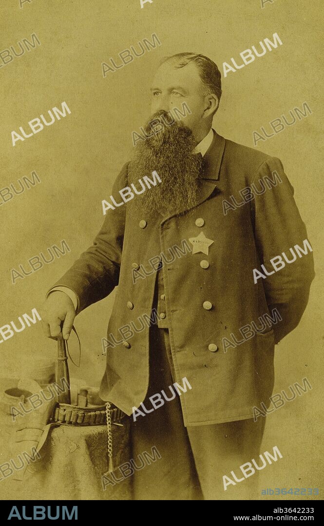 U. S. Marshall With Badge Of Newton, Kansas, Ca. 1890S. Marshall Standing In Tripps' Studio Posed Here With His Holstered Revolver, Gun Belt, Billy Club, And Sports A Great Five-Star Marshall Badge., F.D. Tripp, 1890.