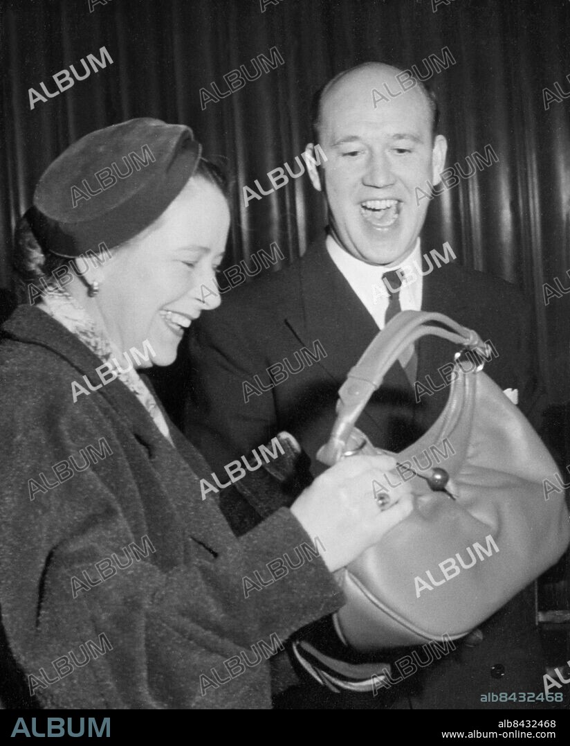 Orig. bildtext... Sittinitti den 18/12 1954 En handväska, i lådleken, blev bytet för damen ur publiken, som valde lådan. Anm. Programledare Handväskor CD265 Tävlingar persons: LENNART HYLAND sites: SVERIGE.