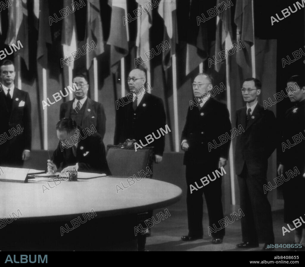 China First to Sign Chapter -- V.K. Wellington Koo, Chinese ambassador to the court of St. James, (Seated) is first to sign the United Nations security chapter, Standing behind, (L-R) are: Parker Hart, U.S. state department Hu Lin, Tune Pi-wu, Chun-Mai Carson change, Li Hwang, and Miss Wu-fang, members of the Chinese delegations. June 26, 1945. (Photo by AP Wirephoto).